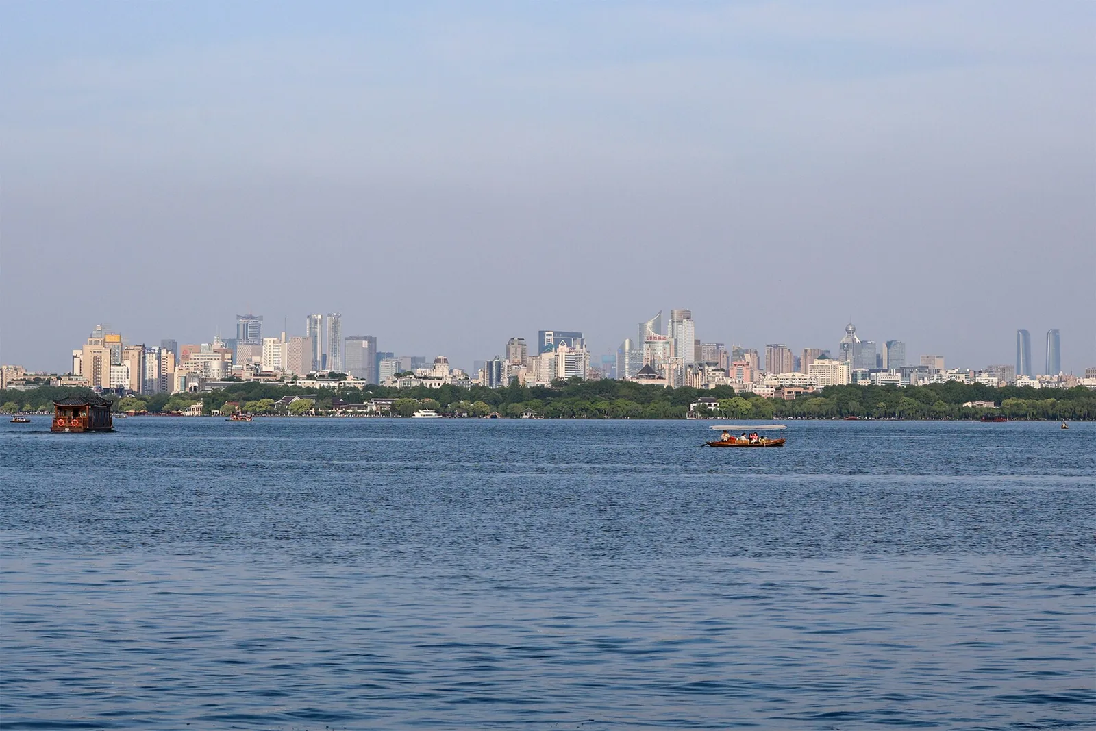 West Lake and the Hangzhou skyline on a calm day.